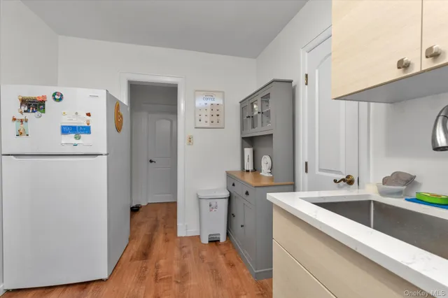 a view of a kitchen with sink and refrigerator