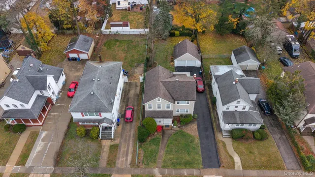 an aerial view of residential houses with outdoor space and parking