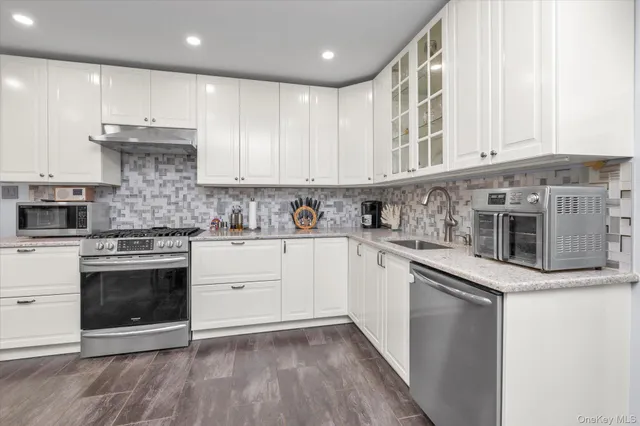 a kitchen with stainless steel appliances granite countertop a stove and a sink