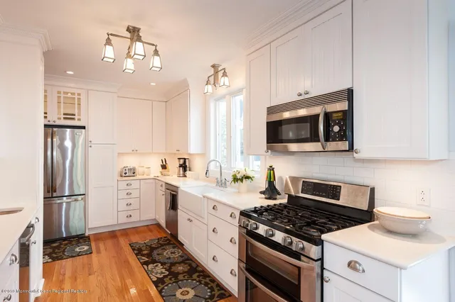 a kitchen with stainless steel appliances a stove microwave and sink