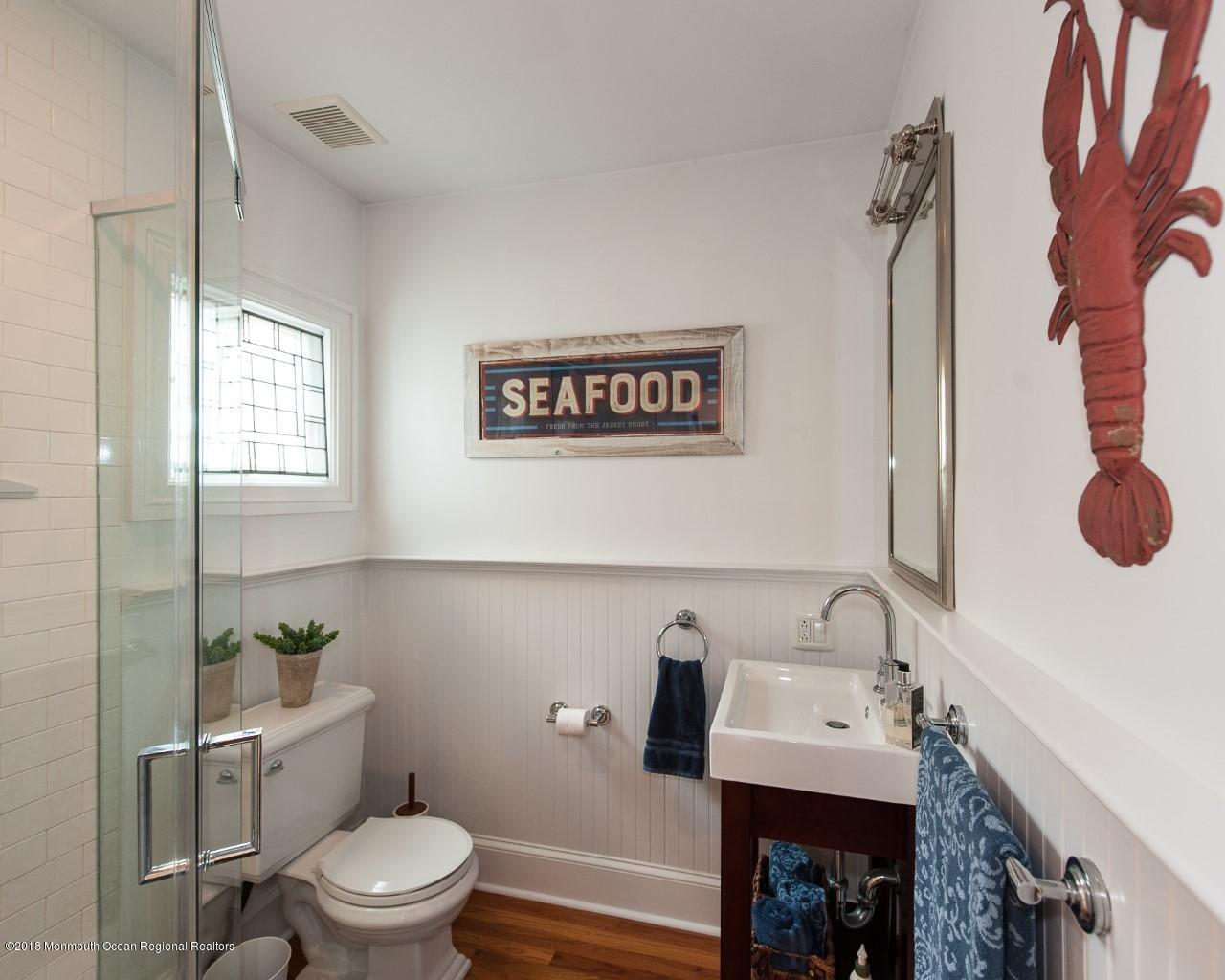 21 Surf Avenue Ocean Grove, NJ 07756 - Photo 10 of 20 a bathroom with a toilet sink and mirror