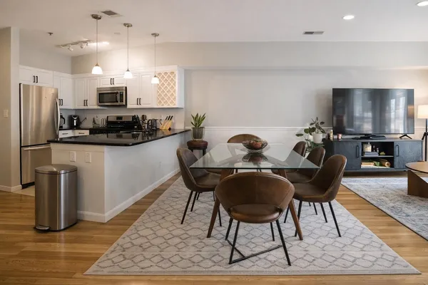 a dining room with furniture and kitchen view