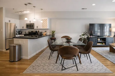 a dining room with furniture and kitchen view