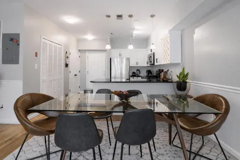 a kitchen with a dining table chairs and a stove