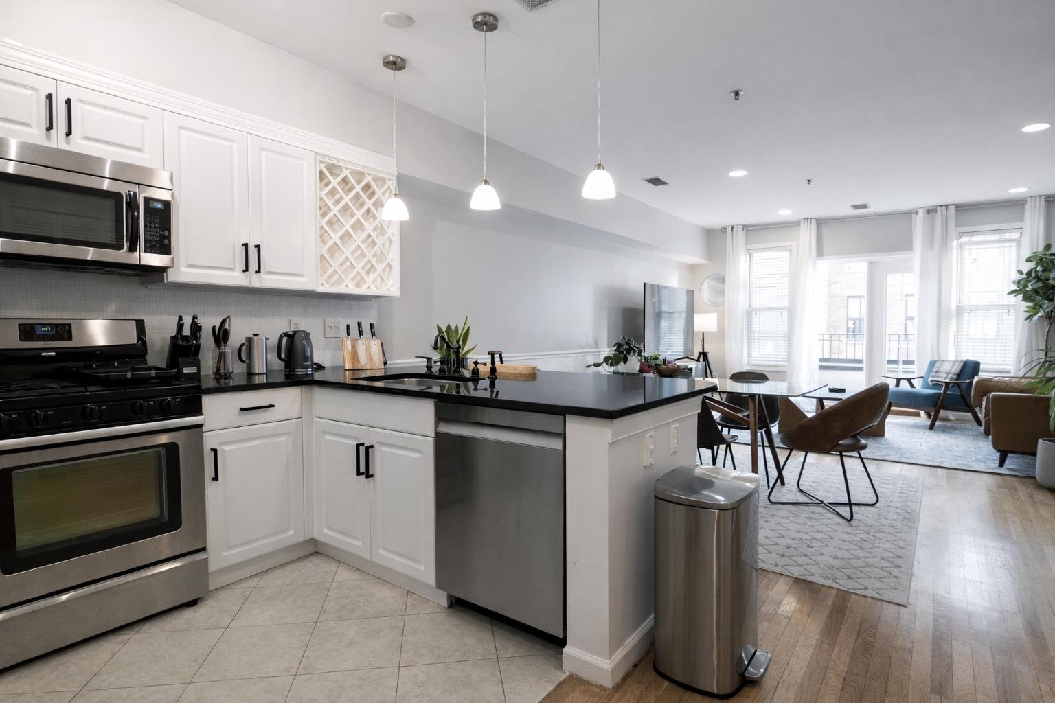 901 Madison Street, Unit 5F Hoboken, NJ 07030 - Photo 8 of 20 a kitchen with stainless steel appliances granite countertop a stove a sink a refrigerator a microwave a dining table and chairs