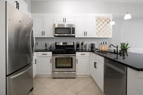 a kitchen with stainless steel appliances a refrigerator sink and microwave