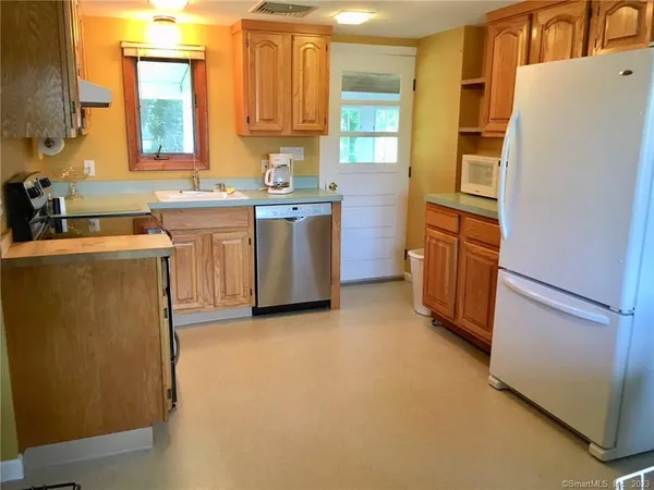 a kitchen with a refrigerator sink stove and cabinets