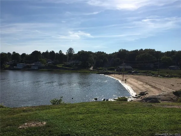 a view of a lake with green field and trees