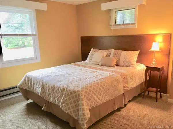 a large bed sitting in a bedroom next to a window