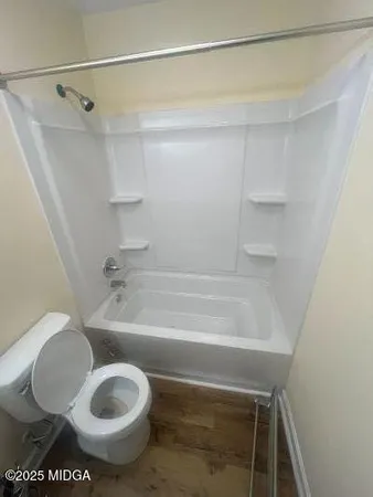 a bathroom with a toilet and a shower