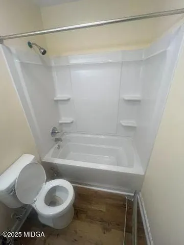 a bathroom with a toilet and a shower