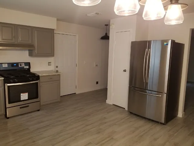 a kitchen with stainless steel appliances a refrigerator a sink and cabinets