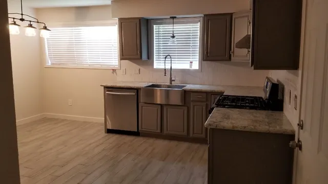 a kitchen with stainless steel appliances granite countertop a sink stove and cabinets