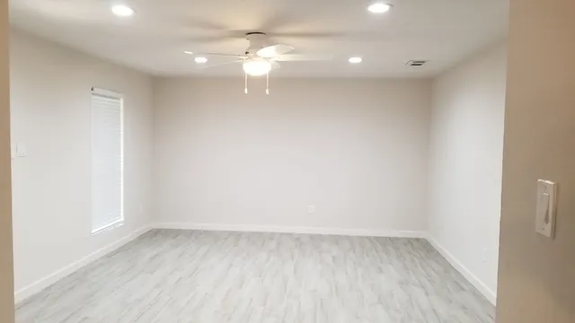 a view of a room with wooden floor and fan