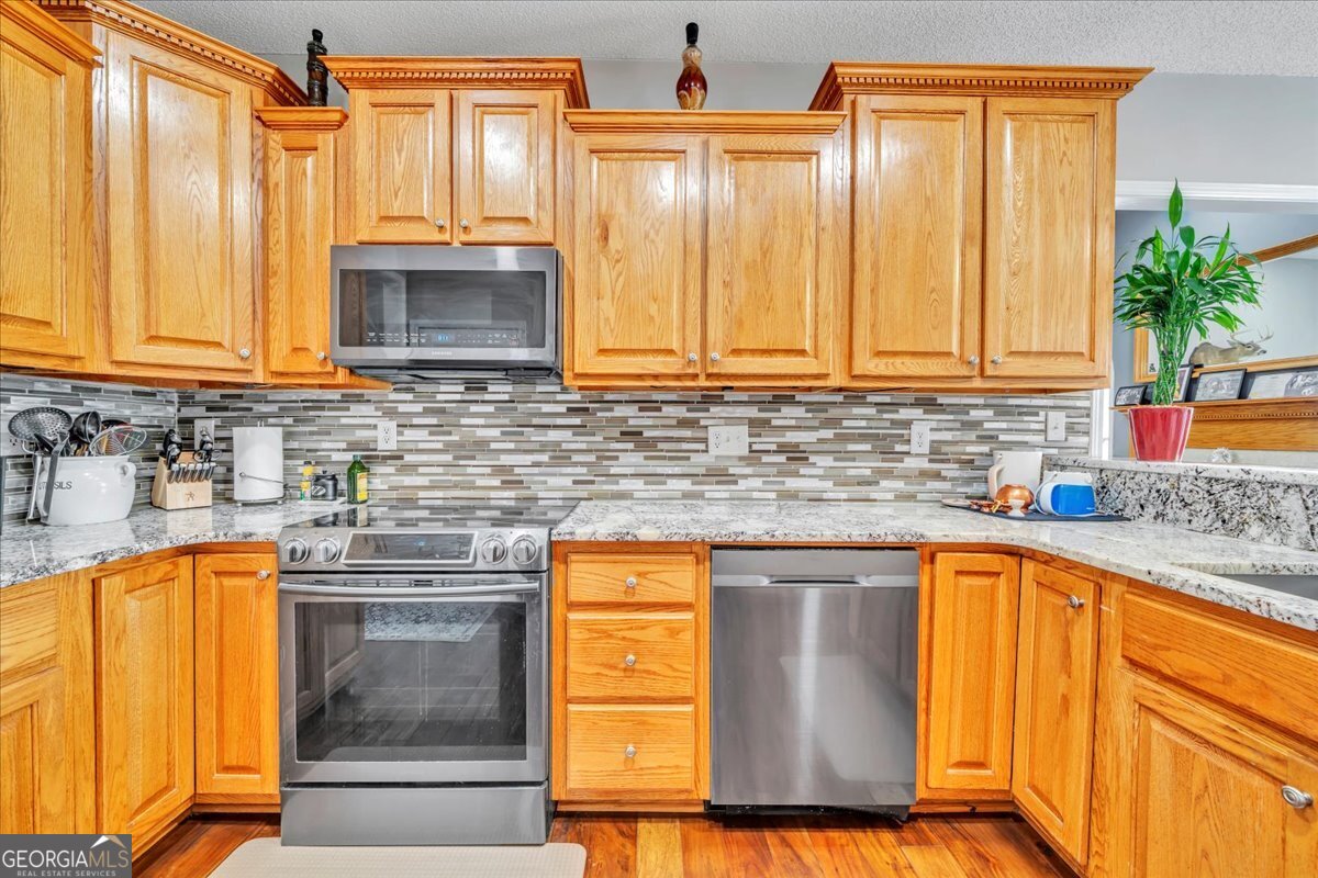 605 Dodds Walk Macon, GA 31220 - Photo 11 of 68 a kitchen with stainless steel appliances granite countertop a sink stove and cabinets