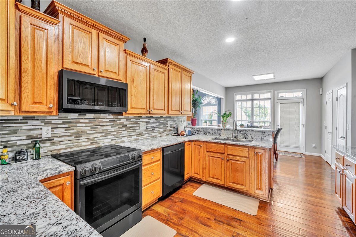 605 Dodds Walk Macon, GA 31220 - Photo 12 of 68 a kitchen with stainless steel appliances granite countertop a stove a sink and a microwave