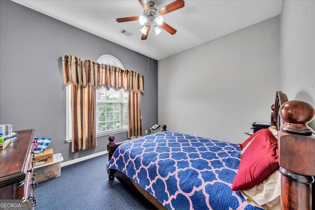 605 Dodds Walk Macon, GA 31220 - Photo 26 of 68 a bedroom with a bed and a chandelier