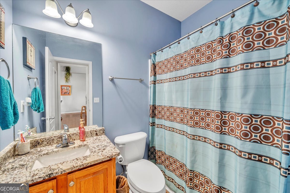 605 Dodds Walk Macon, GA 31220 - Photo 28 of 68 a bathroom with a granite countertop sink mirror vanity and toilet