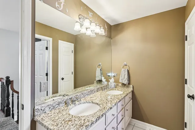 a bathroom with a granite countertop sink a mirror and a shower