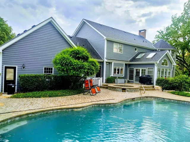a view of pool with outdoor seating and a garden