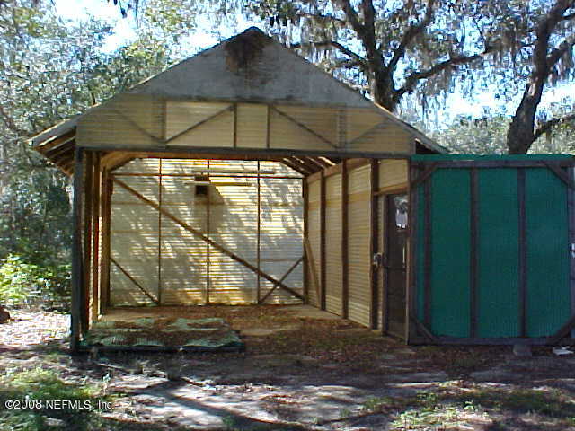 396 Beecher Springs Road Crescent City, FL 32112 - Photo 16 of 17 a table and chair under an umbrella in backyard
