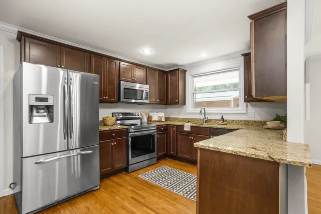 a kitchen with stainless steel appliances granite countertop a refrigerator stove microwave and sink