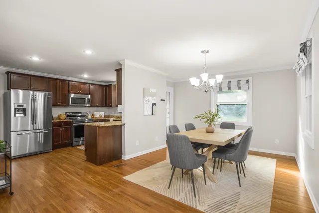 a view of a dining room with furniture a chandelier and wooden floor