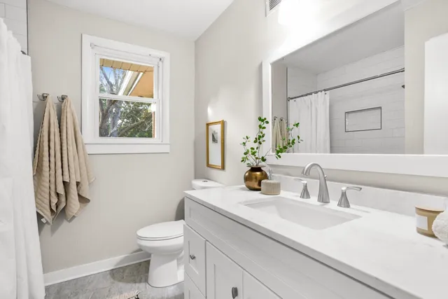 a bathroom with a toilet sink and mirror