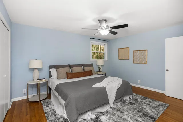 a bedroom with a large bed and a wooden floor