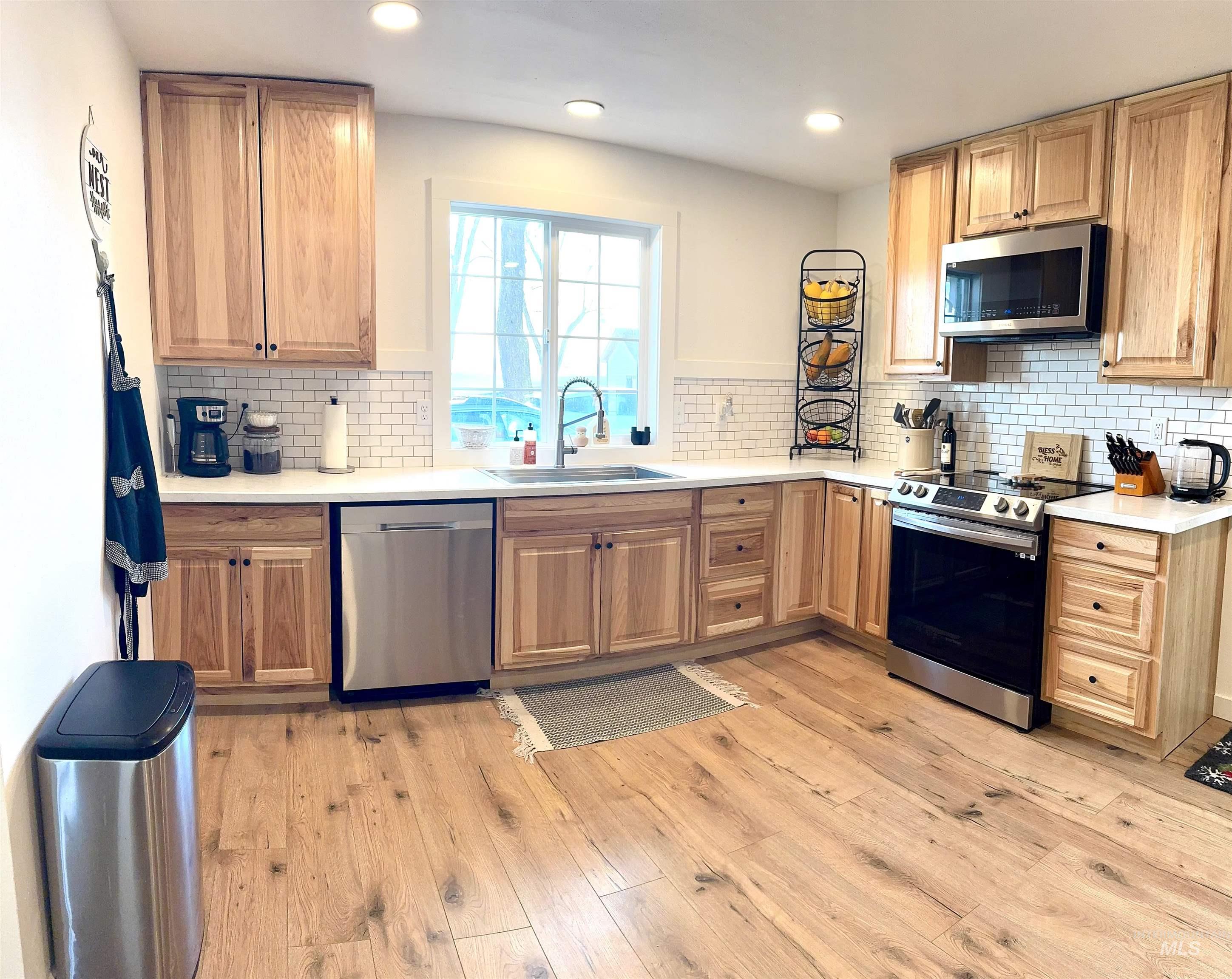 16078 Hoffman Road Kendrick, ID 83537 - Photo 7 of 29 Kitchen with appliances with stainless steel finishes, backsplash, light wood-style flooring, and recessed lighting