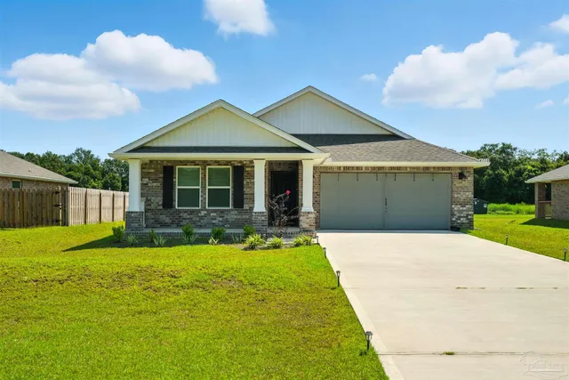 a front view of a house with yard and green space