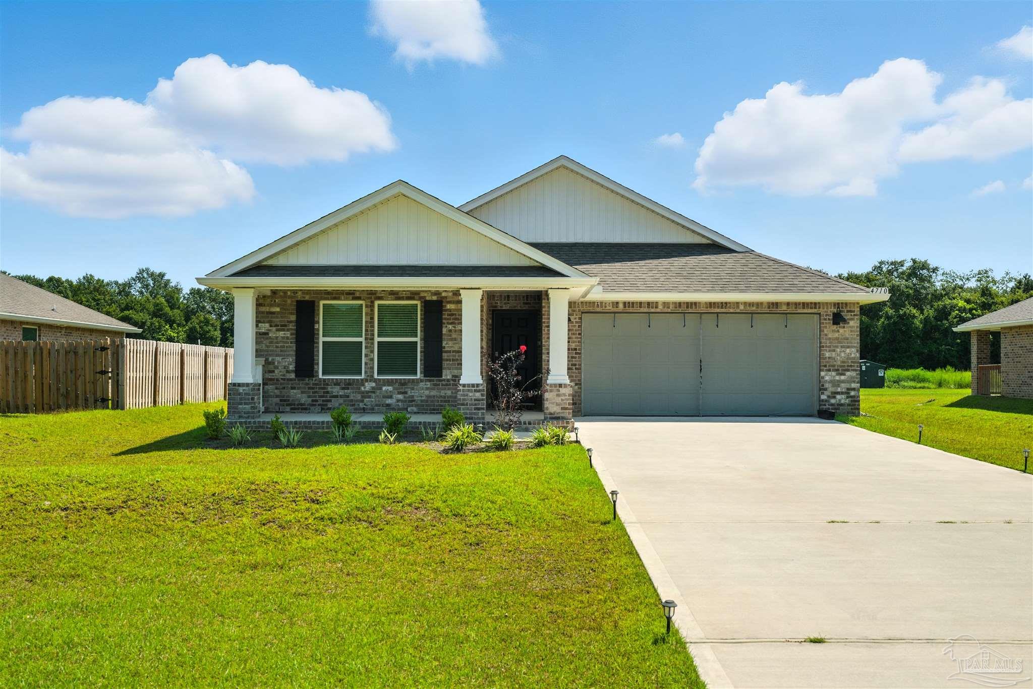 a front view of a house with yard and green space