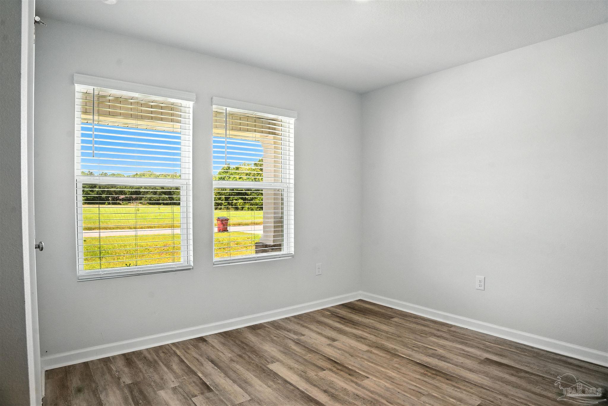 4710 Carl Booker Road Milton, FL 32583 - Photo 14 of 54 a view of an empty room with wooden floor and a window