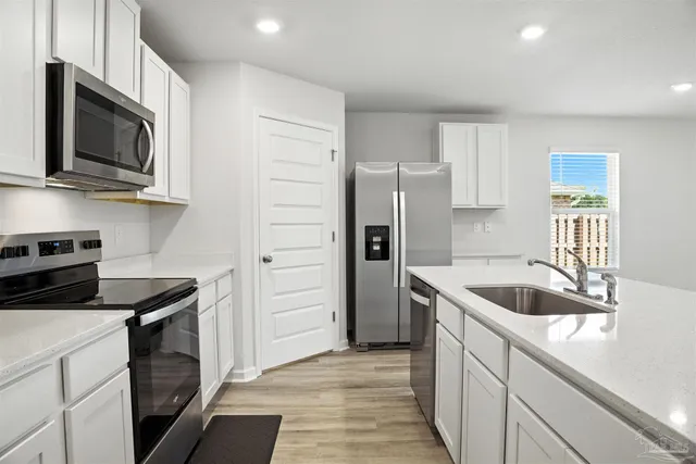 a kitchen with stainless steel appliances granite countertop a sink and a microwave