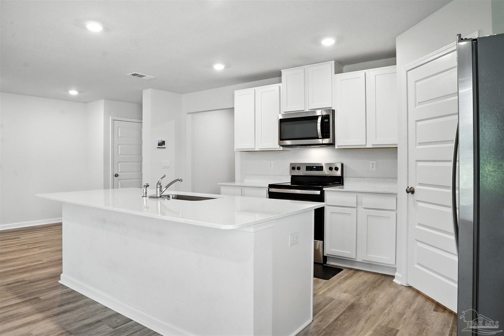4710 Carl Booker Road Milton, FL 32583 - Photo 22 of 54 a kitchen with stainless steel appliances granite countertop a sink stove and refrigerator