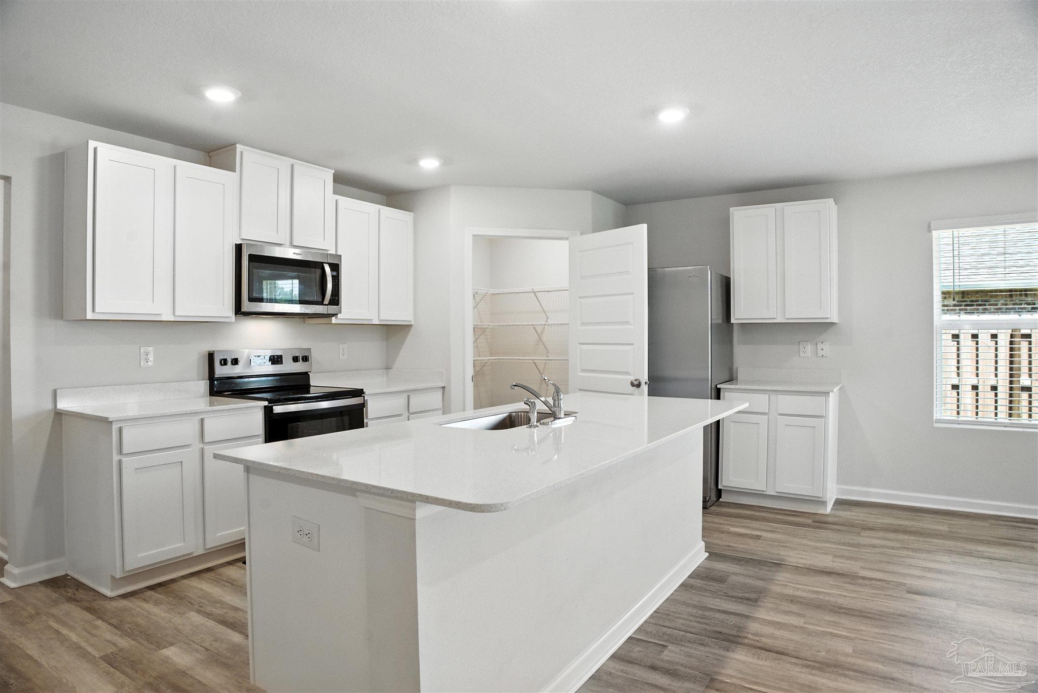 4710 Carl Booker Road Milton, FL 32583 - Photo 23 of 54 a kitchen with sink a microwave and cabinets