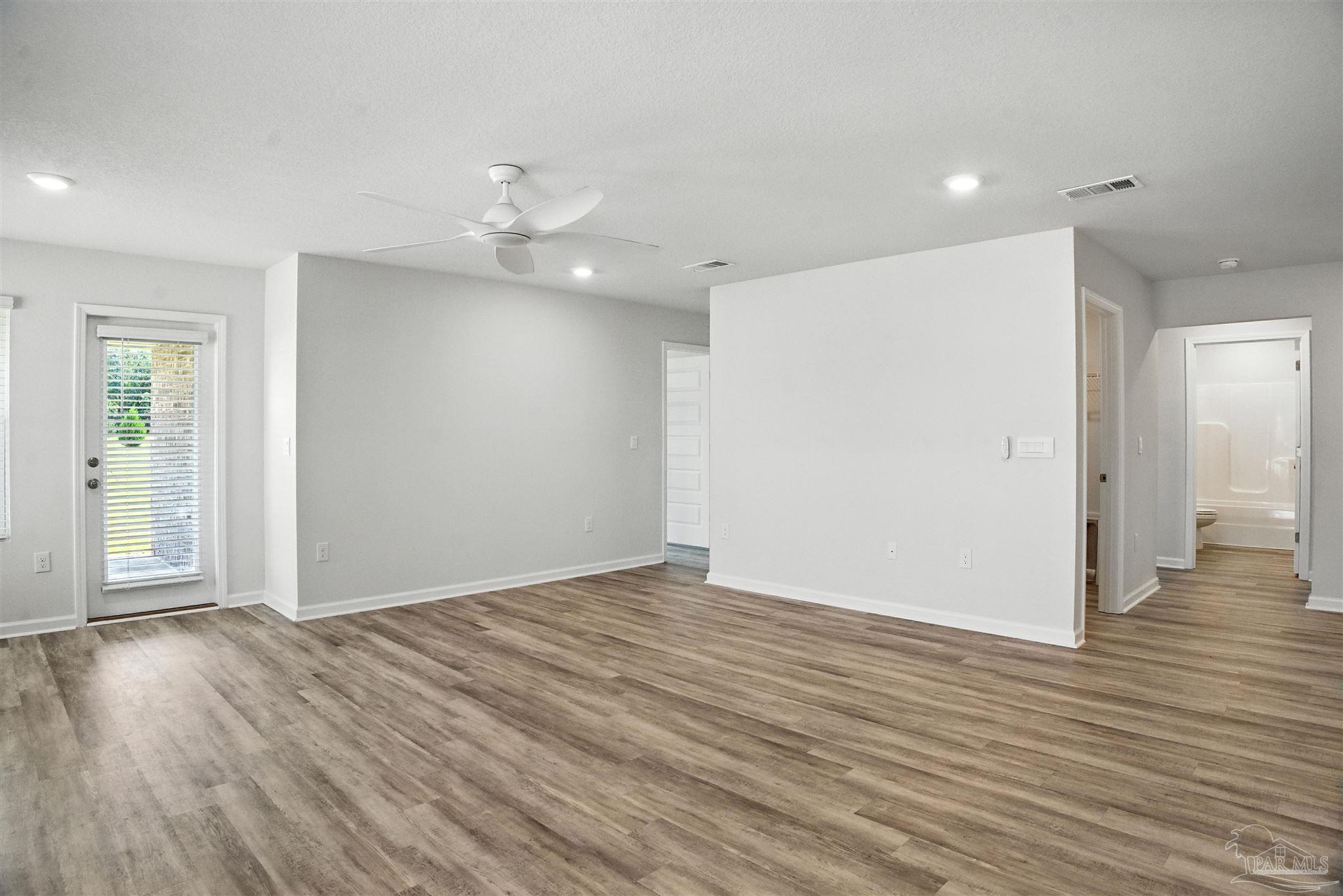 4710 Carl Booker Road Milton, FL 32583 - Photo 24 of 54 an empty room with wooden floor and ceiling fan
