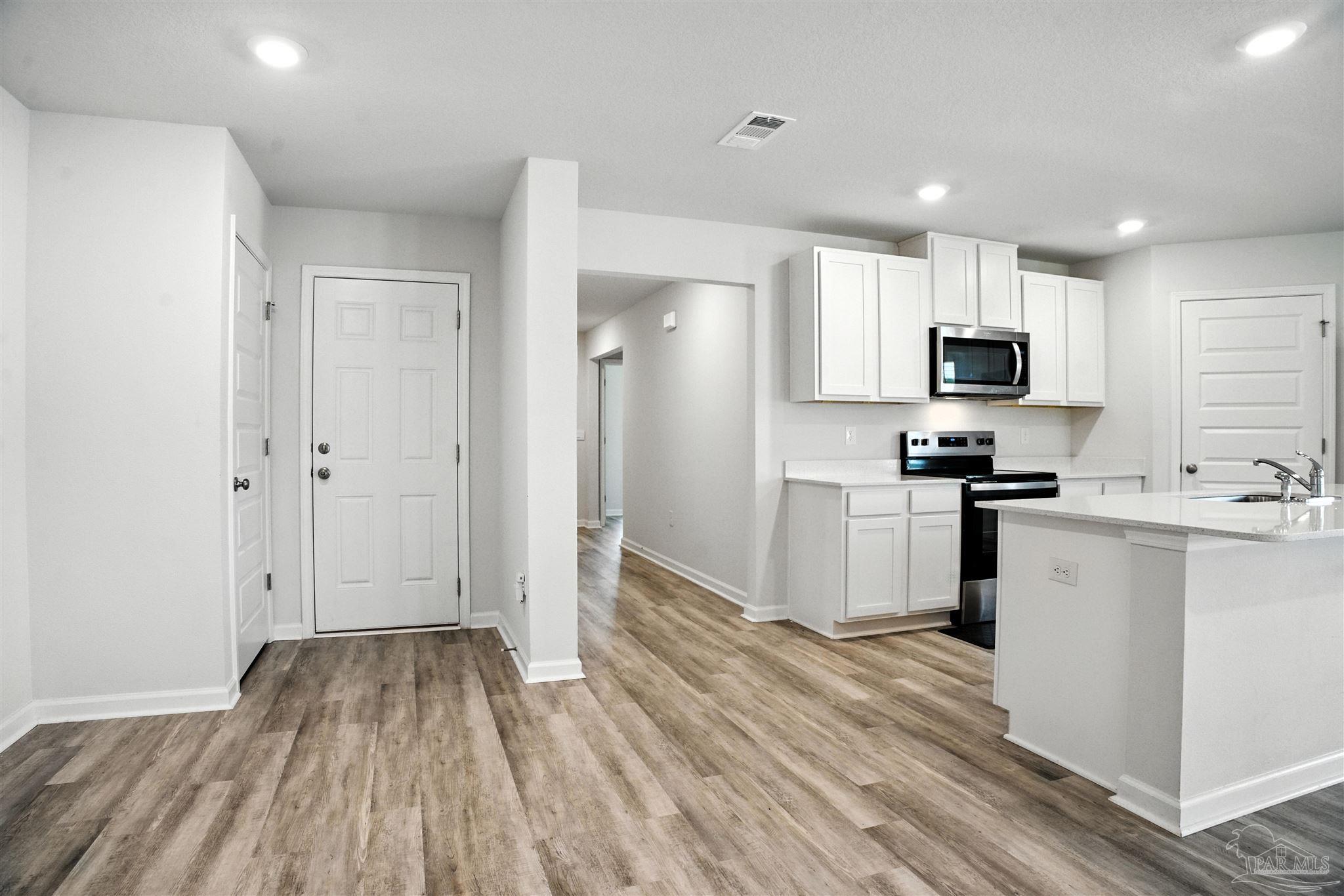 4710 Carl Booker Road Milton, FL 32583 - Photo 27 of 54 a kitchen with granite countertop a refrigerator and a stove top oven