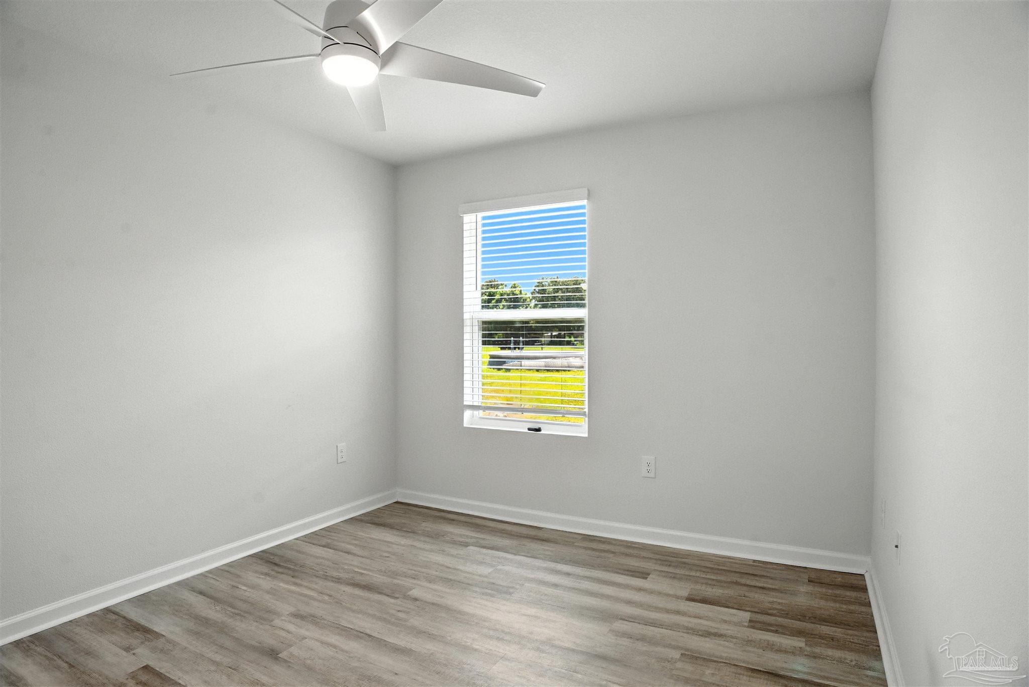 4710 Carl Booker Road Milton, FL 32583 - Photo 28 of 54 an empty room with a window and wooden floor