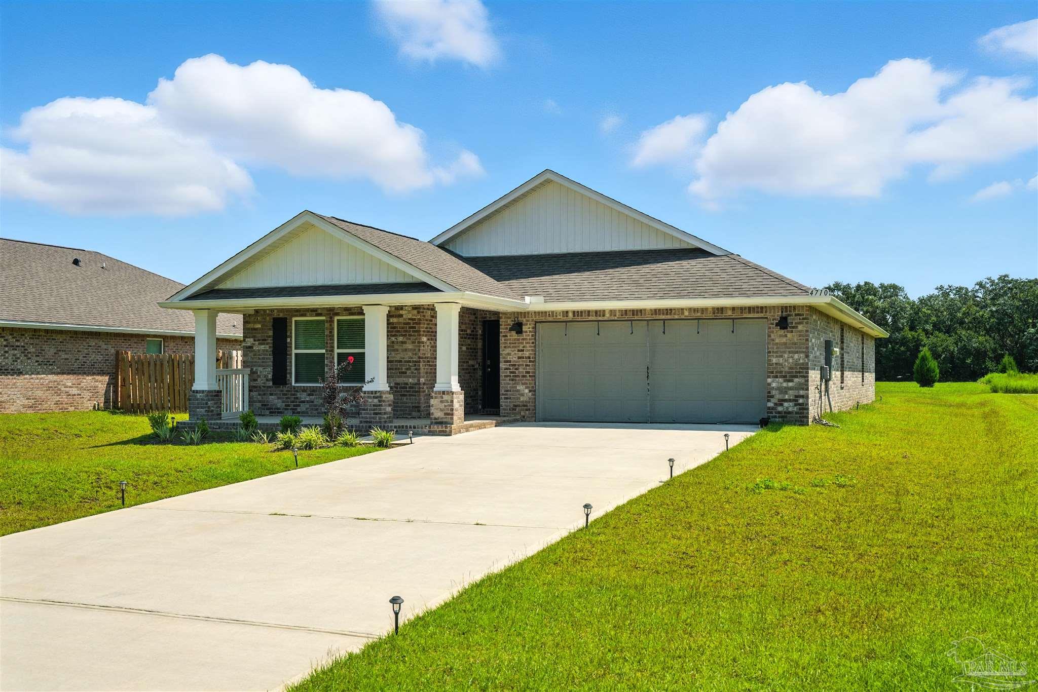 4710 Carl Booker Road Milton, FL 32583 - Photo 3 of 54 a front view of a house with a garden and yard