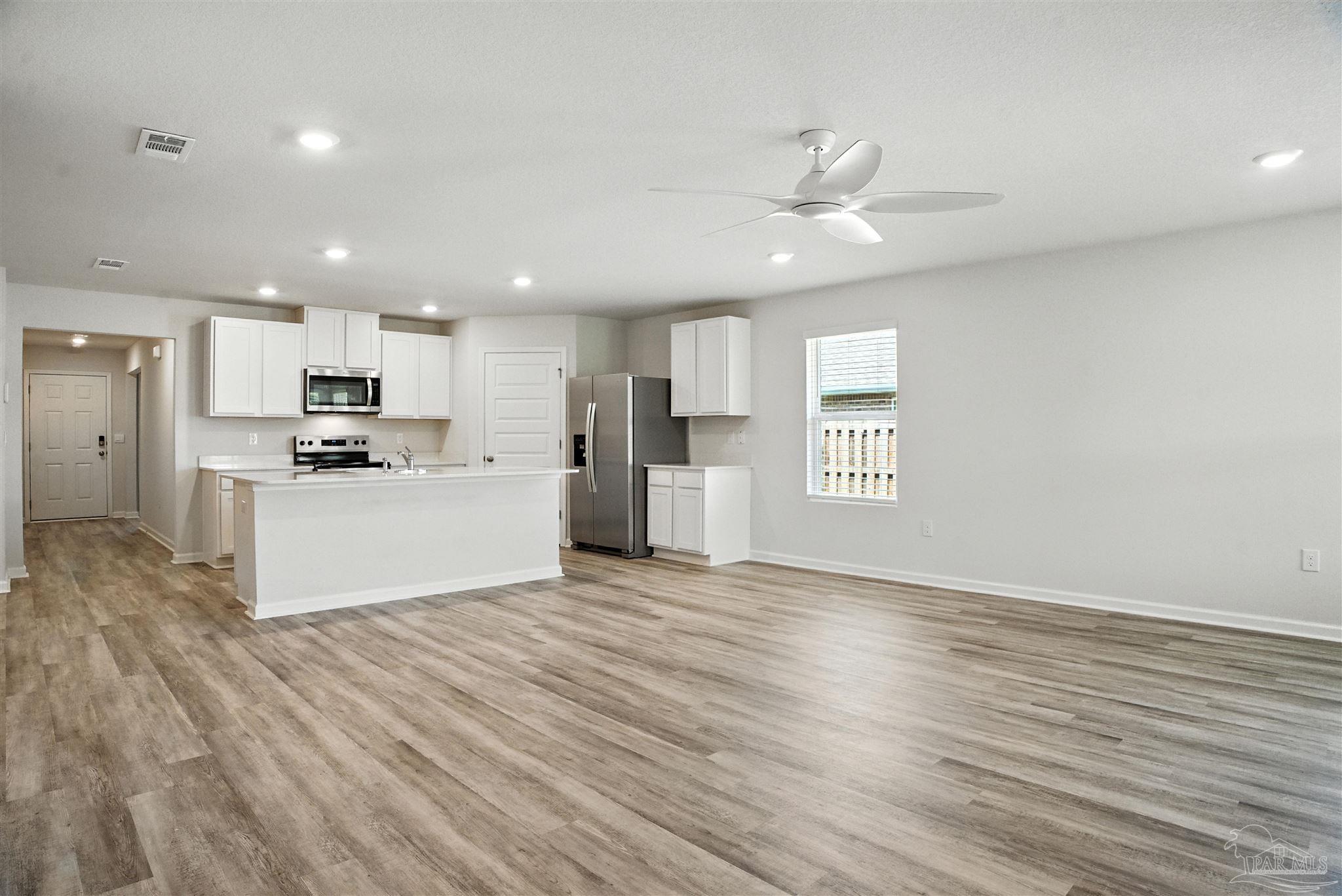 4710 Carl Booker Road Milton, FL 32583 - Photo 33 of 54 a view of kitchen with refrigerator microwave and wooden floor
