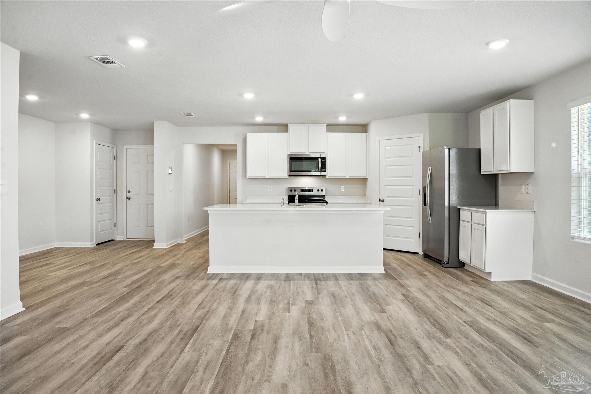 4710 Carl Booker Road Milton, FL 32583 - Photo 34 of 54 a large kitchen with stainless steel appliances a large counter top a sink and a stove