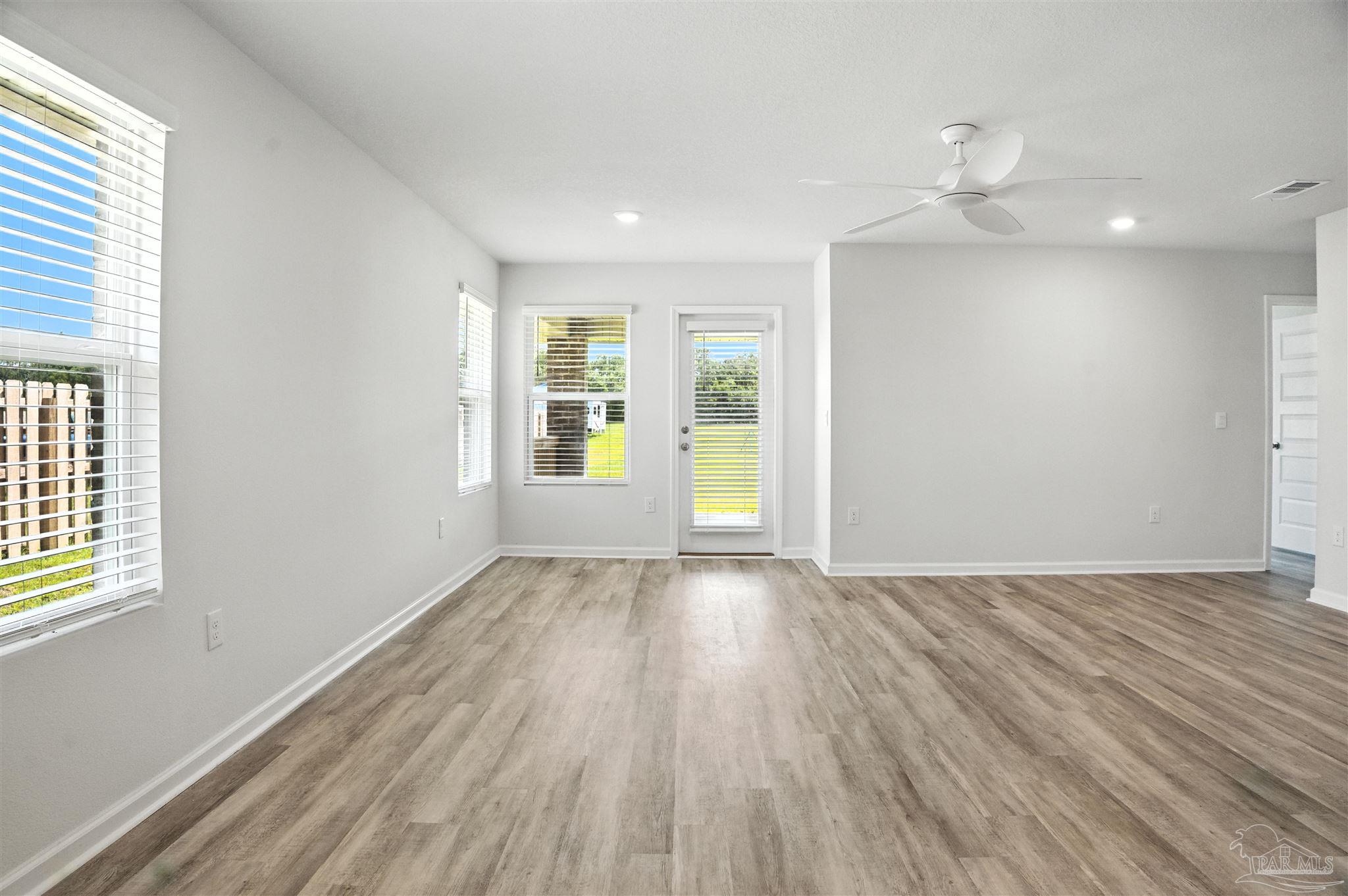 4710 Carl Booker Road Milton, FL 32583 - Photo 36 of 54 an empty room with wooden floor and windows