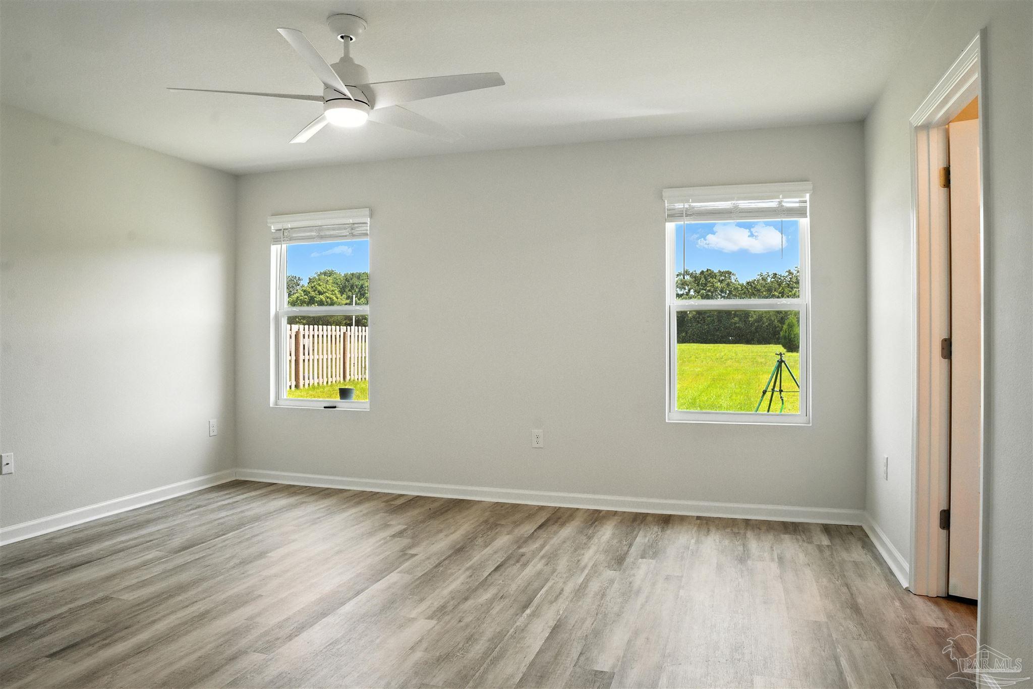 4710 Carl Booker Road Milton, FL 32583 - Photo 37 of 54 an empty room with window and wooden floor