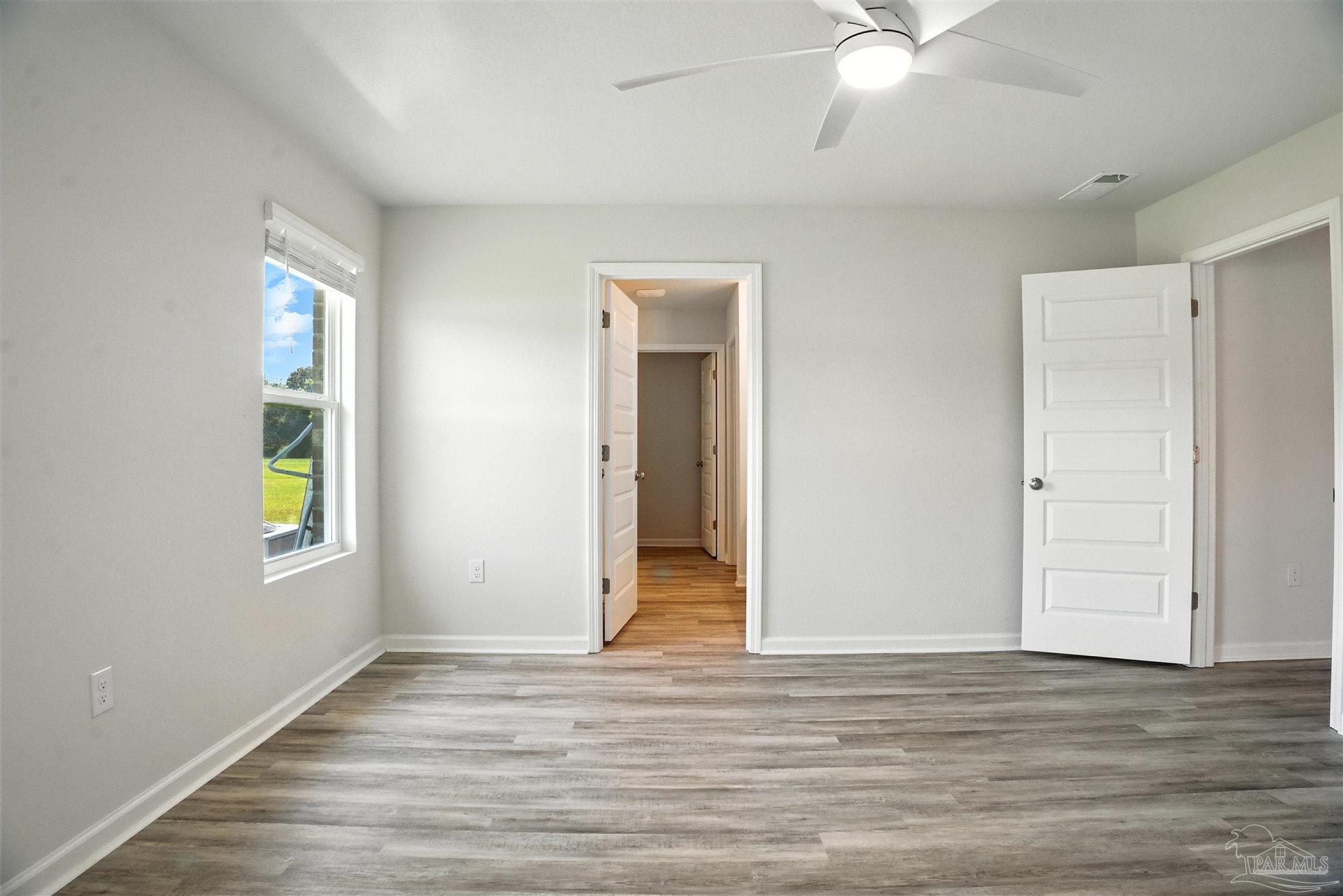 4710 Carl Booker Road Milton, FL 32583 - Photo 39 of 54 an empty room with wooden floor and window