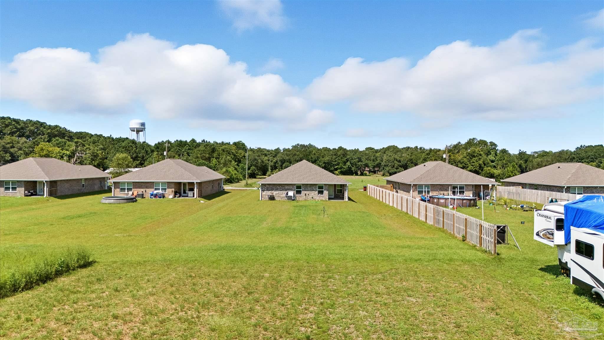 4710 Carl Booker Road Milton, FL 32583 - Photo 49 of 54 a view of an swimming pool with lawn chairs under an umbrella