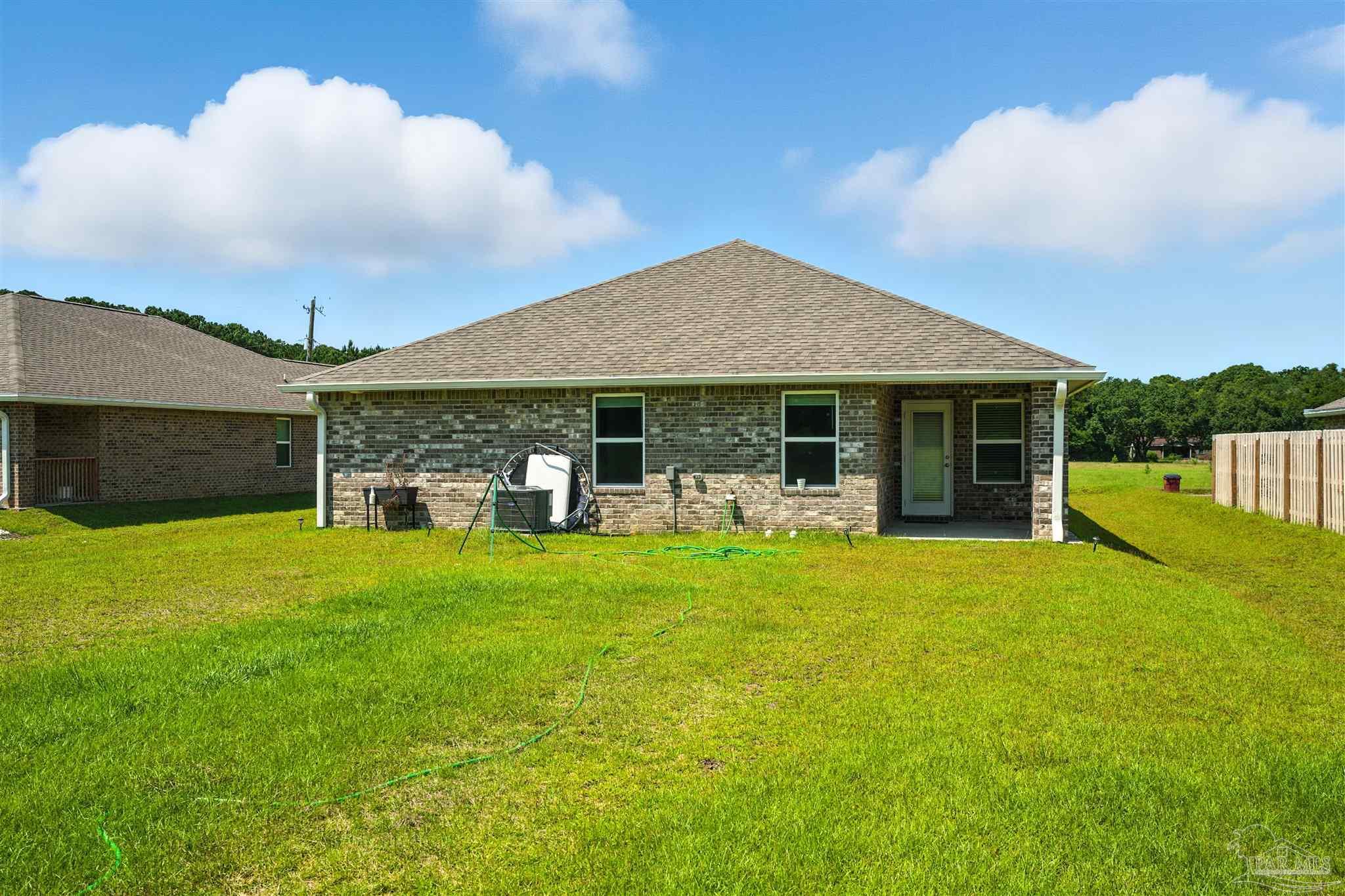 4710 Carl Booker Road Milton, FL 32583 - Photo 9 of 54 a front view of a house with a garden and porch