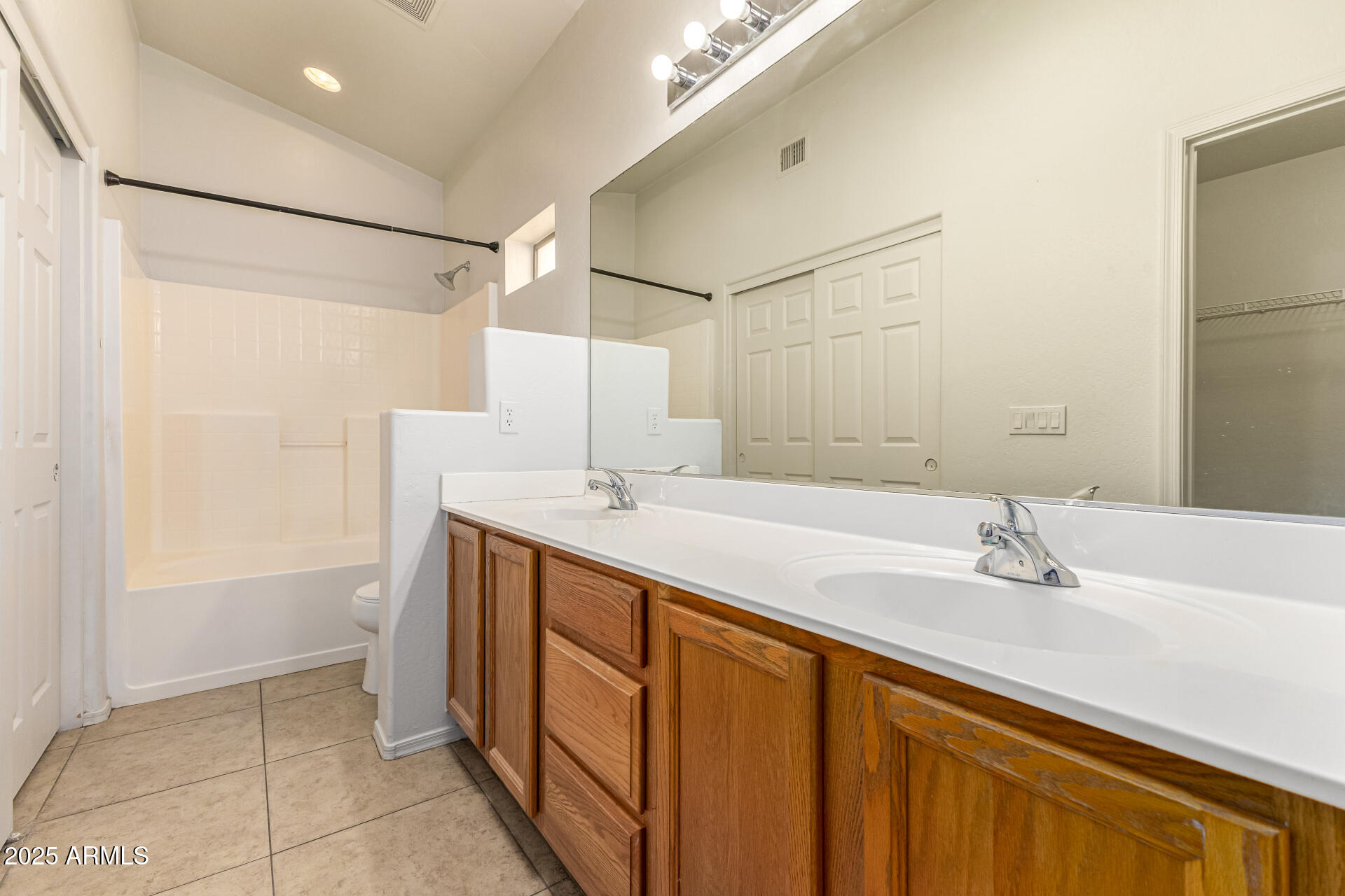 10628 West Coronado Road Avondale, AZ 85392 - Photo 14 of 29 a bathroom with a double vanity sink a mirror and a bathtub