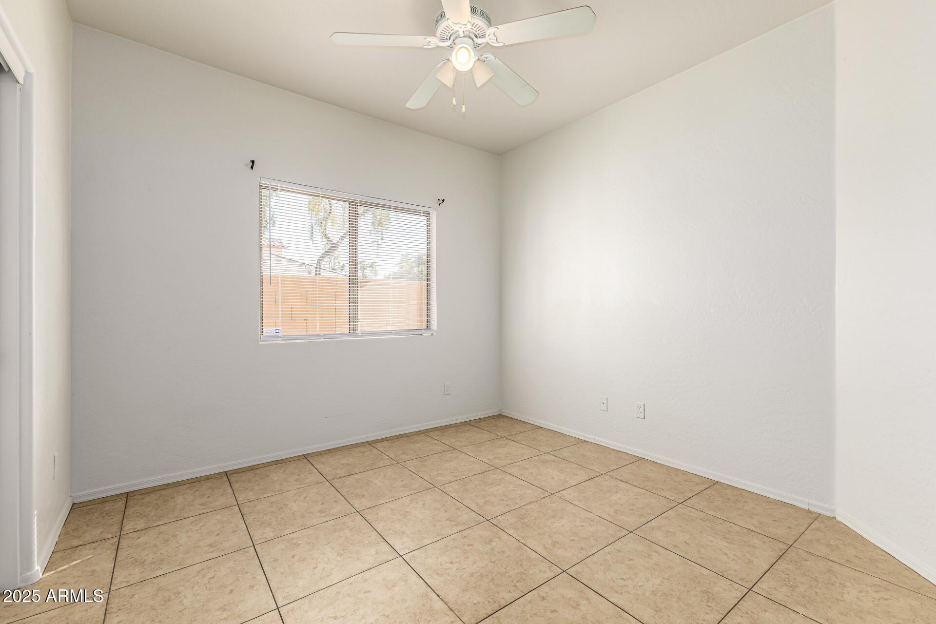 10628 West Coronado Road Avondale, AZ 85392 - Photo 17 of 29 an empty room with a chandelier fan and windows