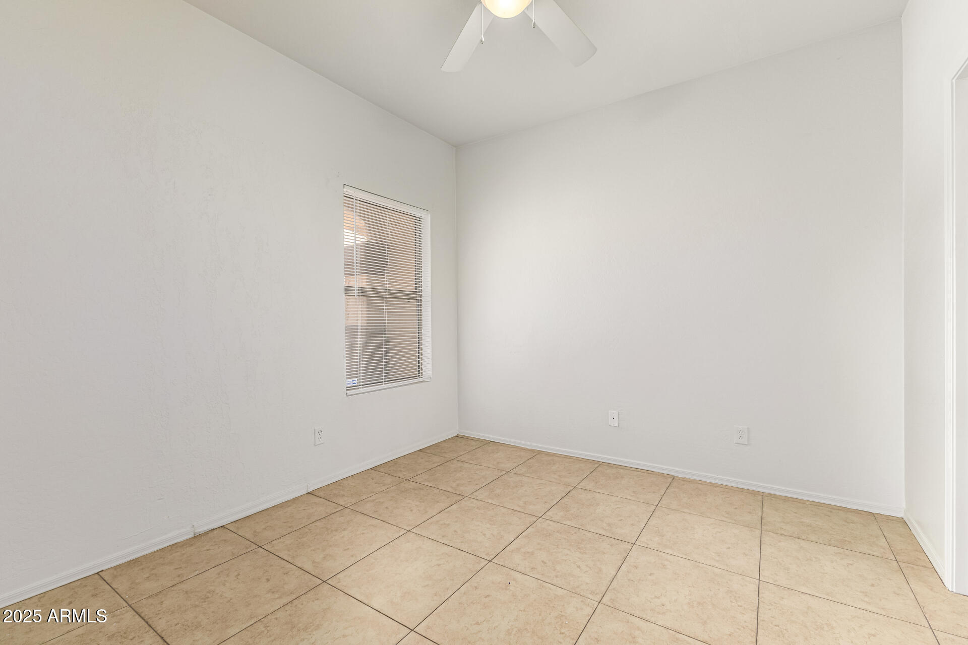 10628 West Coronado Road Avondale, AZ 85392 - Photo 19 of 29 an empty room with a chandelier fan